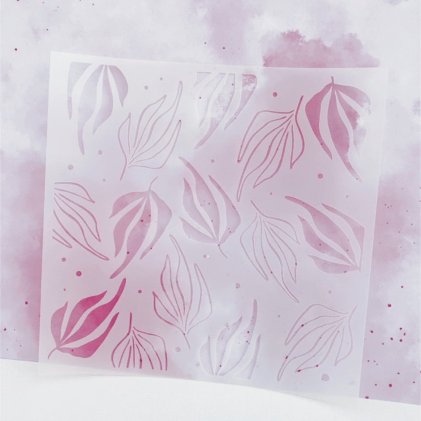 Estêncil plástico translúcido com desenhos recortados de folhas em fundos manchados de rosa e lilás