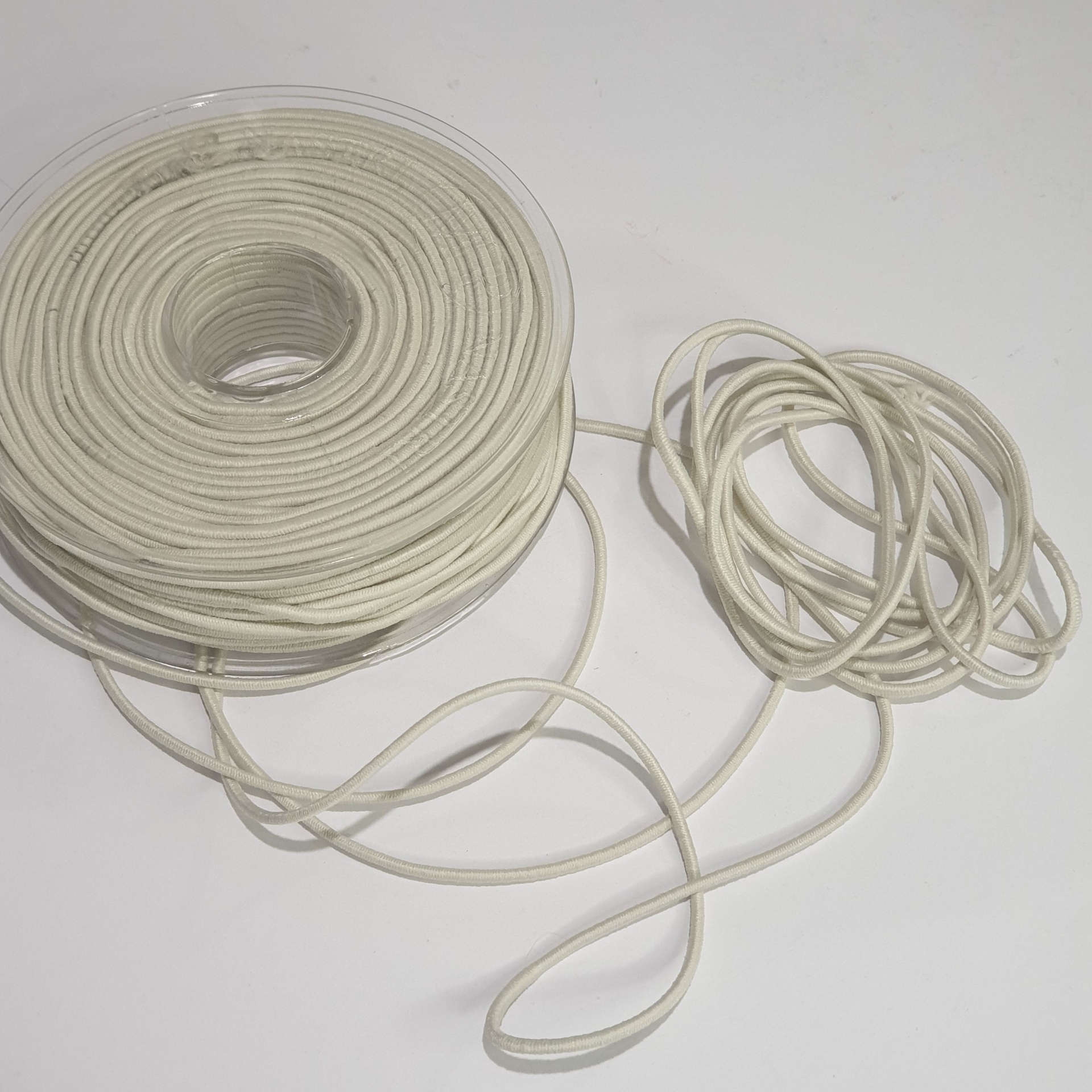 Rolo de cordão branco enrolado com cordão solto