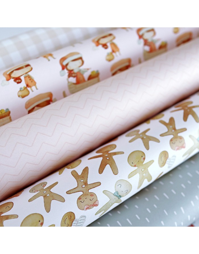 Papéis de embrulho com desenhos de bonecos de gengibre e padrões em tons rosa e cinza.