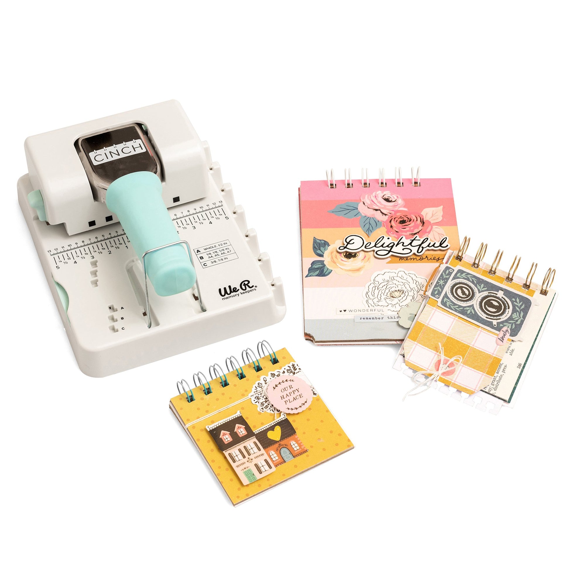 Máquina de encadernação branca com pega azul claro e três cadernos pequenos coloridos com espiral