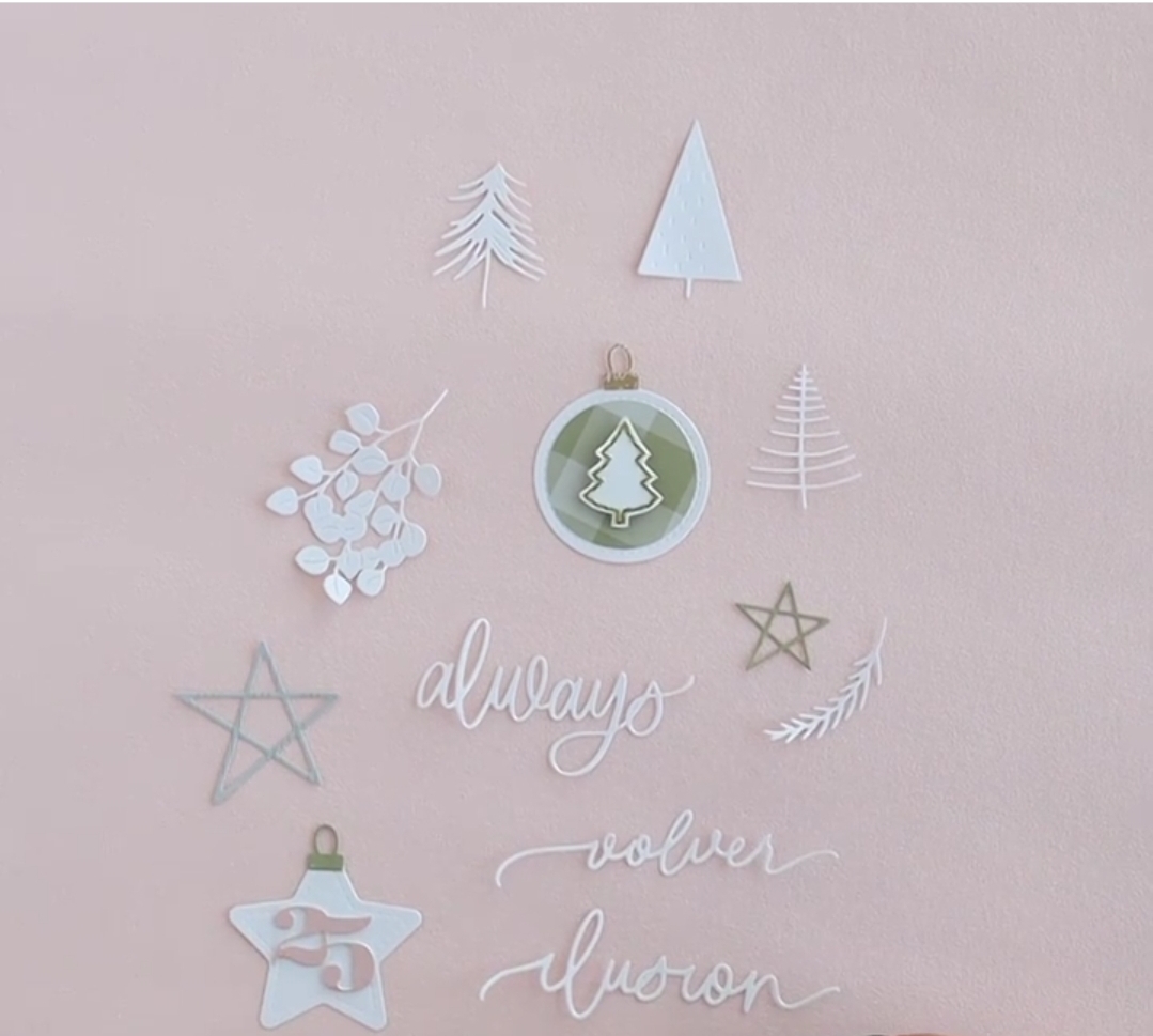 Adesivos decorativos de Natal com árvores, estrelas, ramos e palavras em fundo rosa claro.