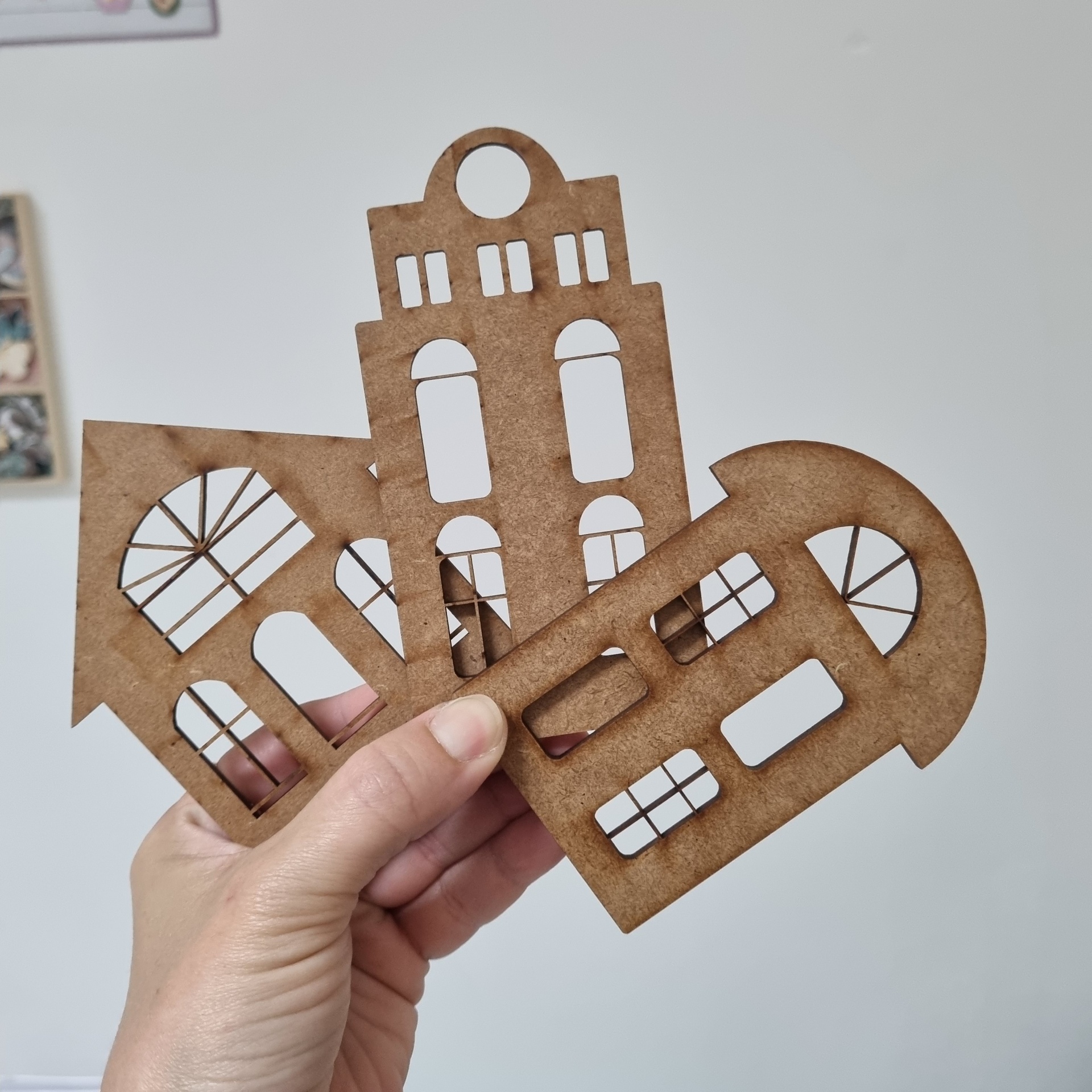 peças de decoração em MDF recortado com formas de janelas e edifícios