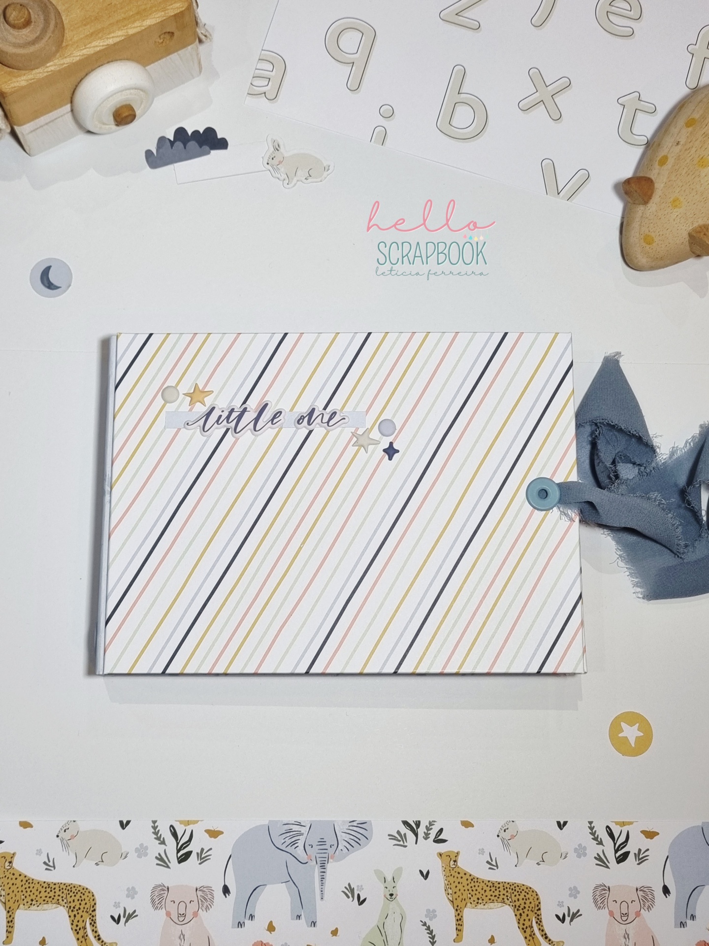 Álbum de scrapbook com riscas diagonais e texto little one