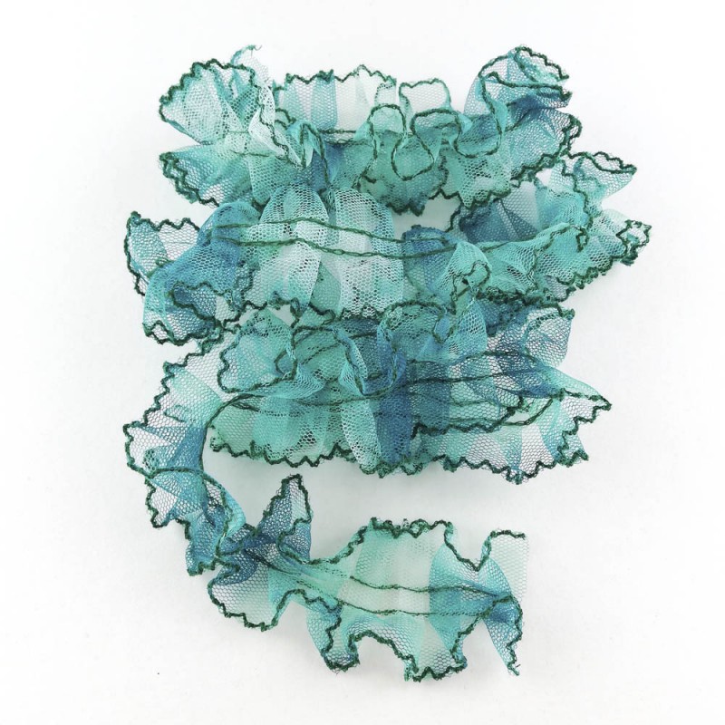 Fita decorativa azul e verde com bordas onduladas sobre fundo branco