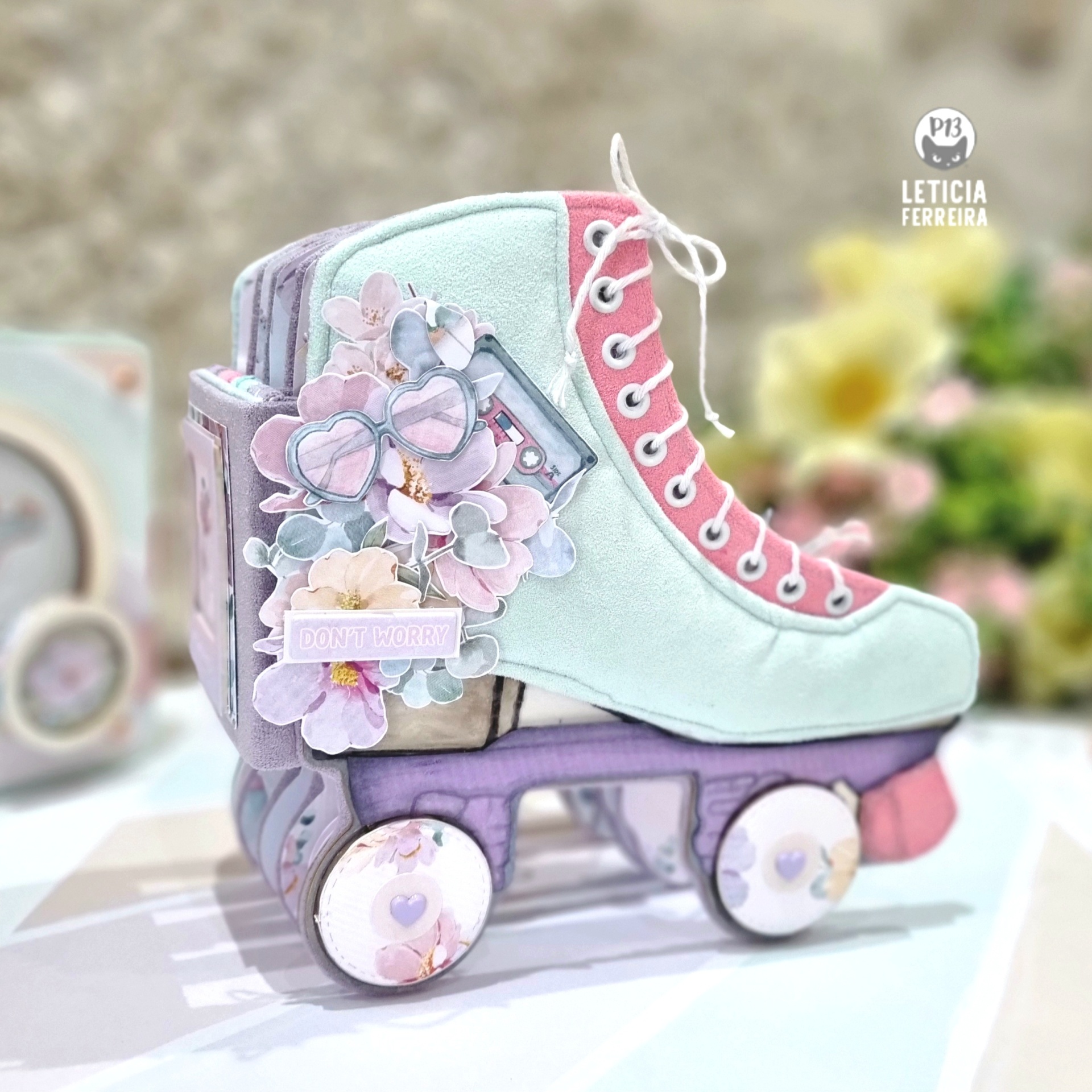 Caixa decorativa em forma de patim de rodas azul e rosa com detalhes florais e texto 'DON'T WORRY'.