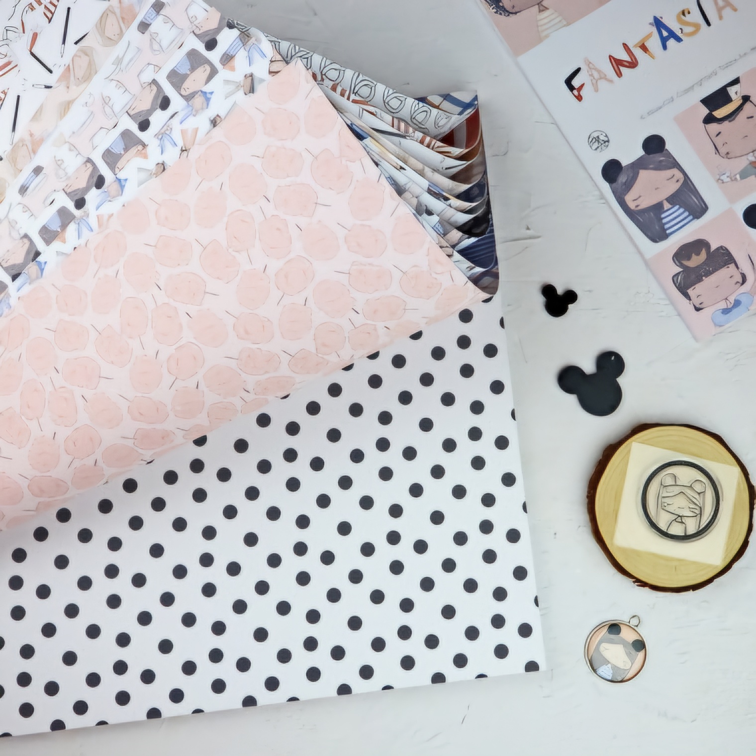 Papéis de embrulho com padrões variados e pequenos objetos decorativos sobre superfície branca