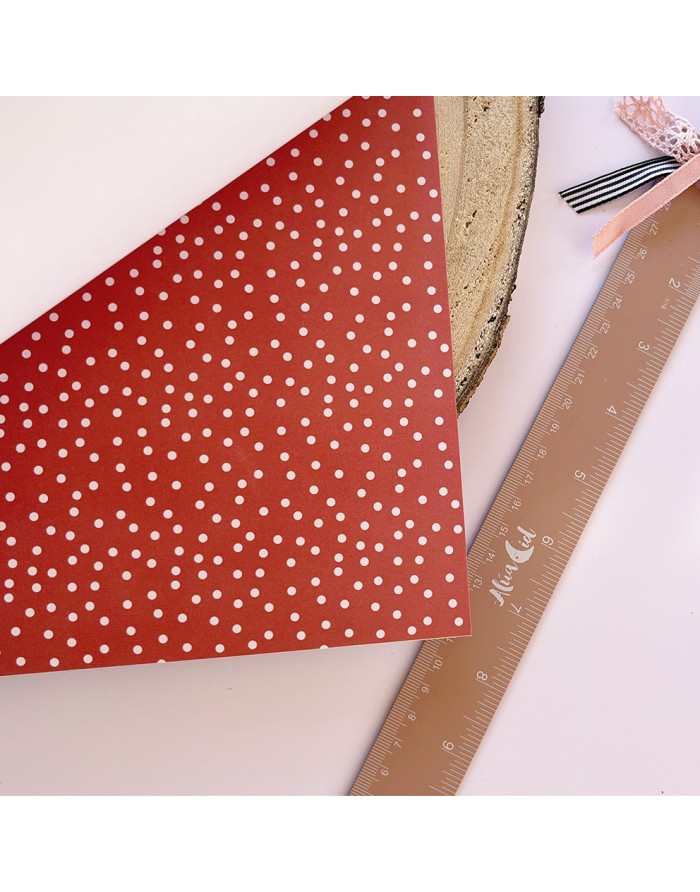 Folha vermelha com bolinhas brancas, régua de madeira com fita rosa e preta