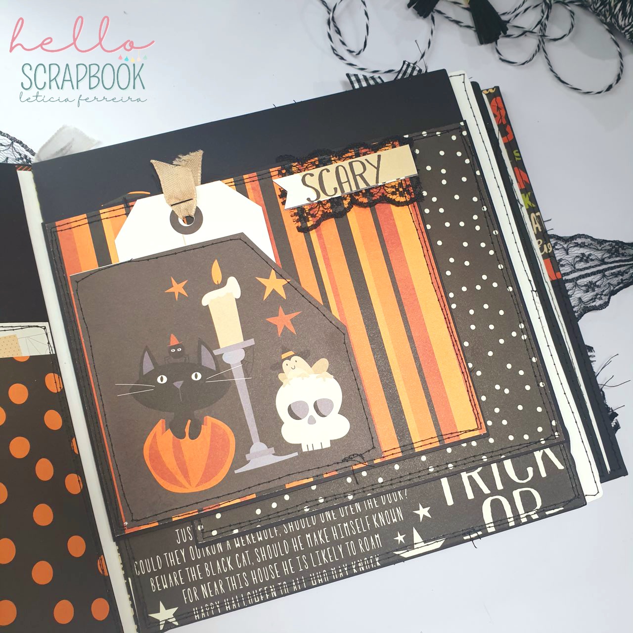 Livro de scrapbook com decoração de Halloween com padrões laranja e preto e imagens de gato preto, abóbora, vela e crânio.