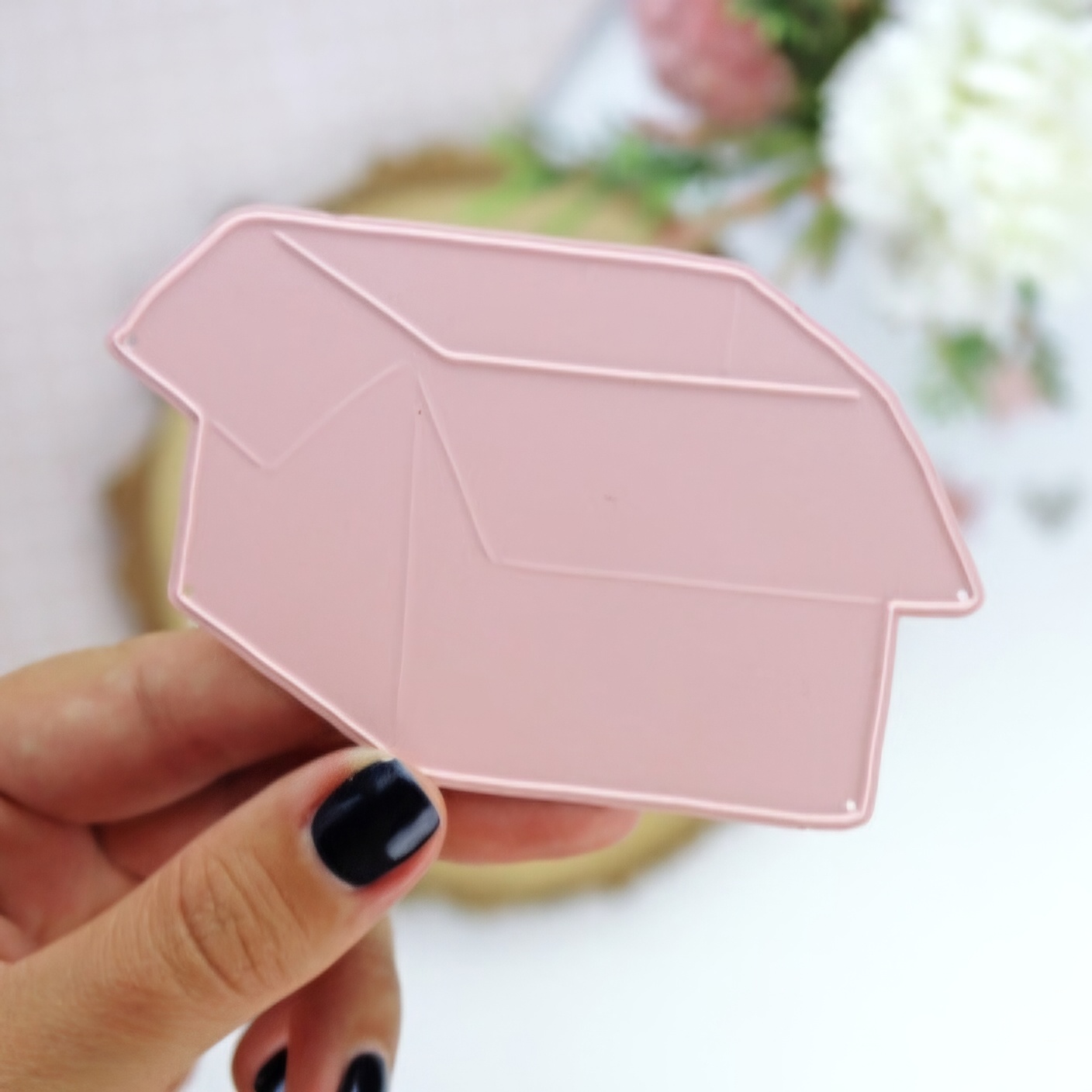 Suporte de acrílico rosa em forma de t-shirt segurado à mão