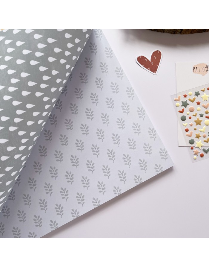 Folha dupla-face de papel decorativo cinza e branco com padrões e adesivos coloridos em formato de estrelas e corações