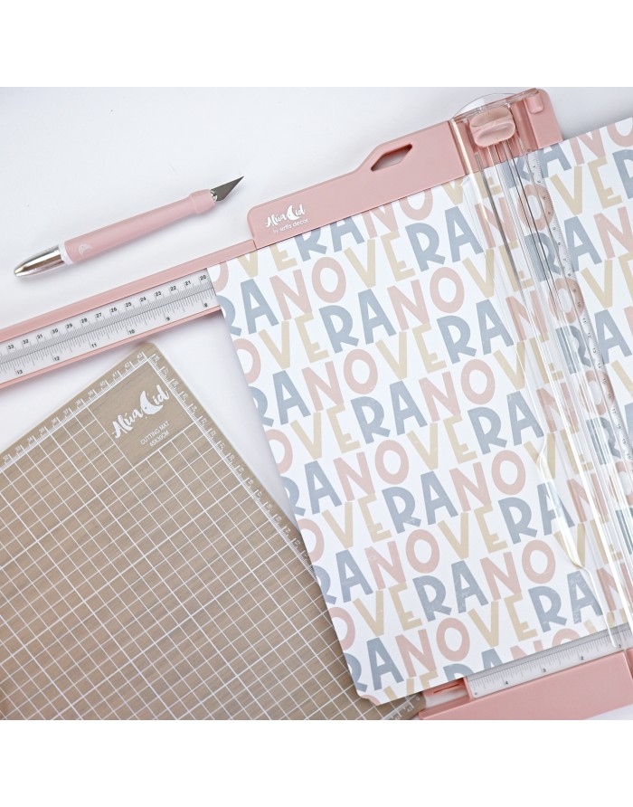 Conjunto de corte com régua, lâmina rosa claro e base quadriculada, padrão com palavras 'VERANO' em tons pastel.
