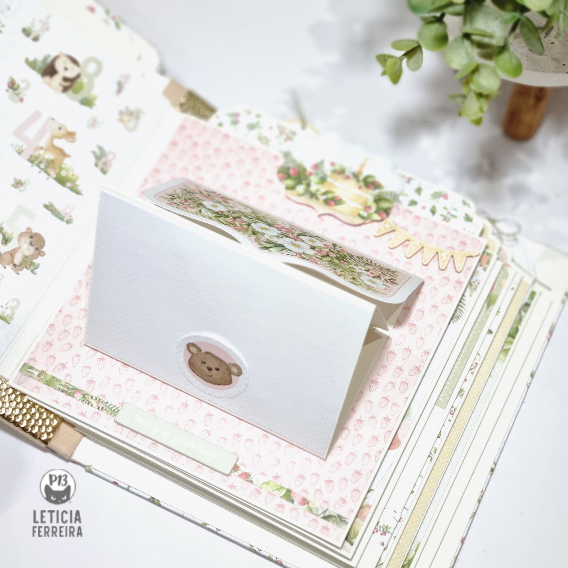 Livro de memórias para bebés com elementos decorativos em scrapbook e envelope com ursinho