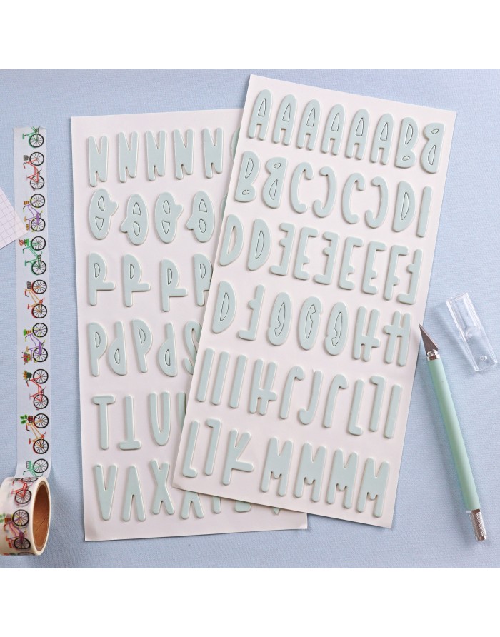 Folhas com autocolantes de letras maiúsculas azul claro, caneta e fita decorativa de bicicletas