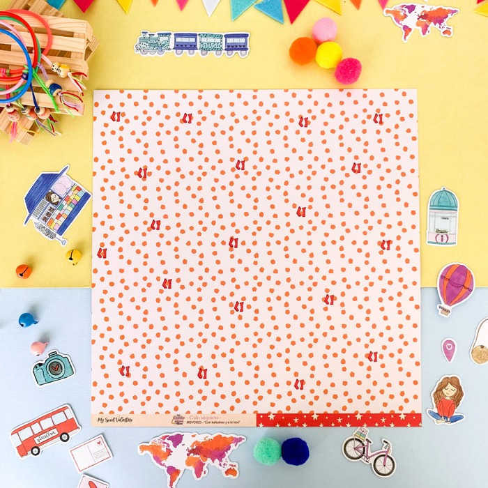 Papel decorativo com padrão de pintas laranja em fundo branco, com recortes de papel coloridos à volta