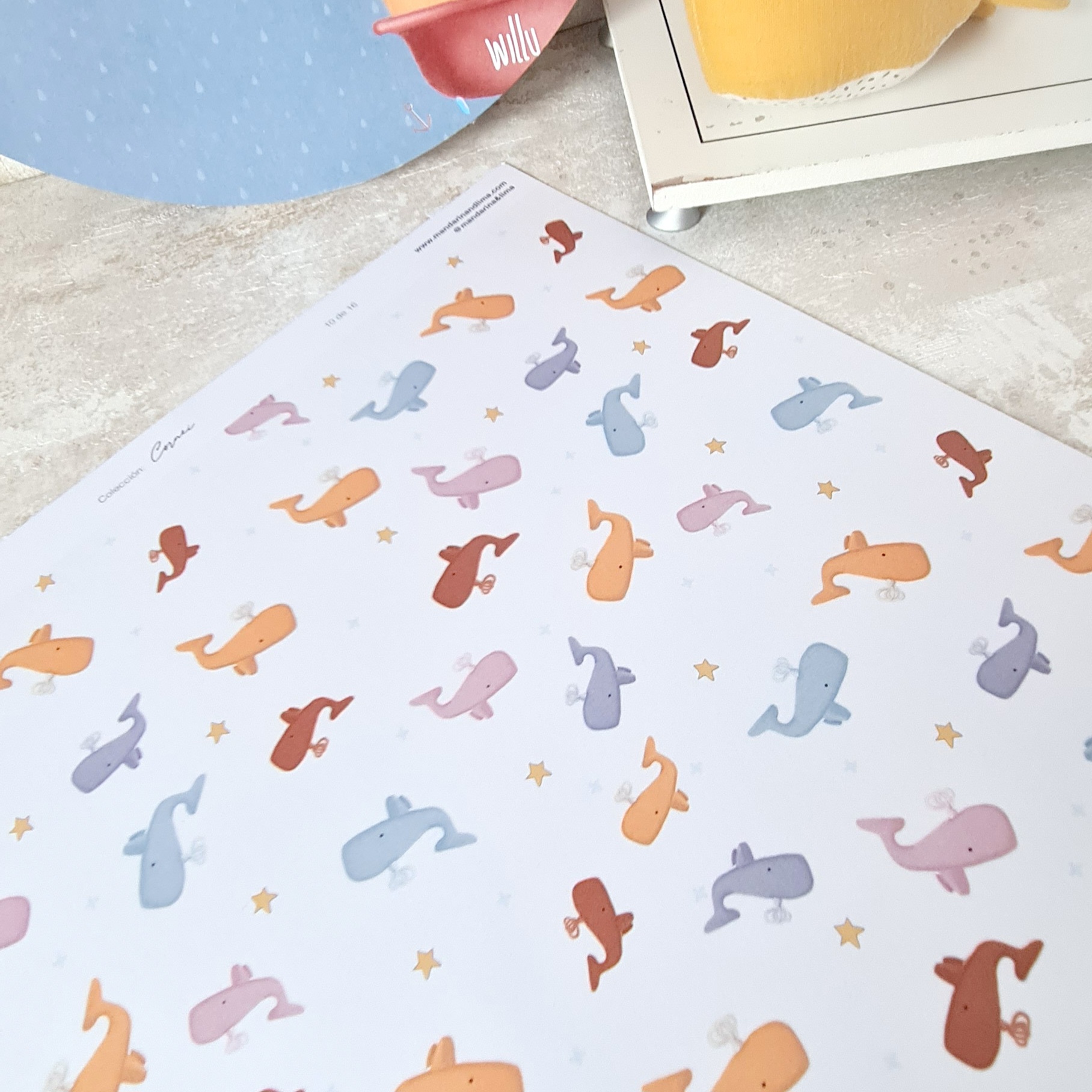 Folha decorativa com padrão de baleias coloridas pastel com estrelas amarelas