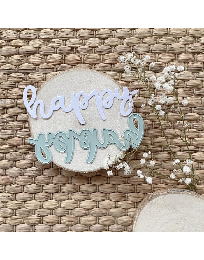 Recortes de palavra em placas sobre base de madeira com flores pequenas brancas, em fundo trançado bege.