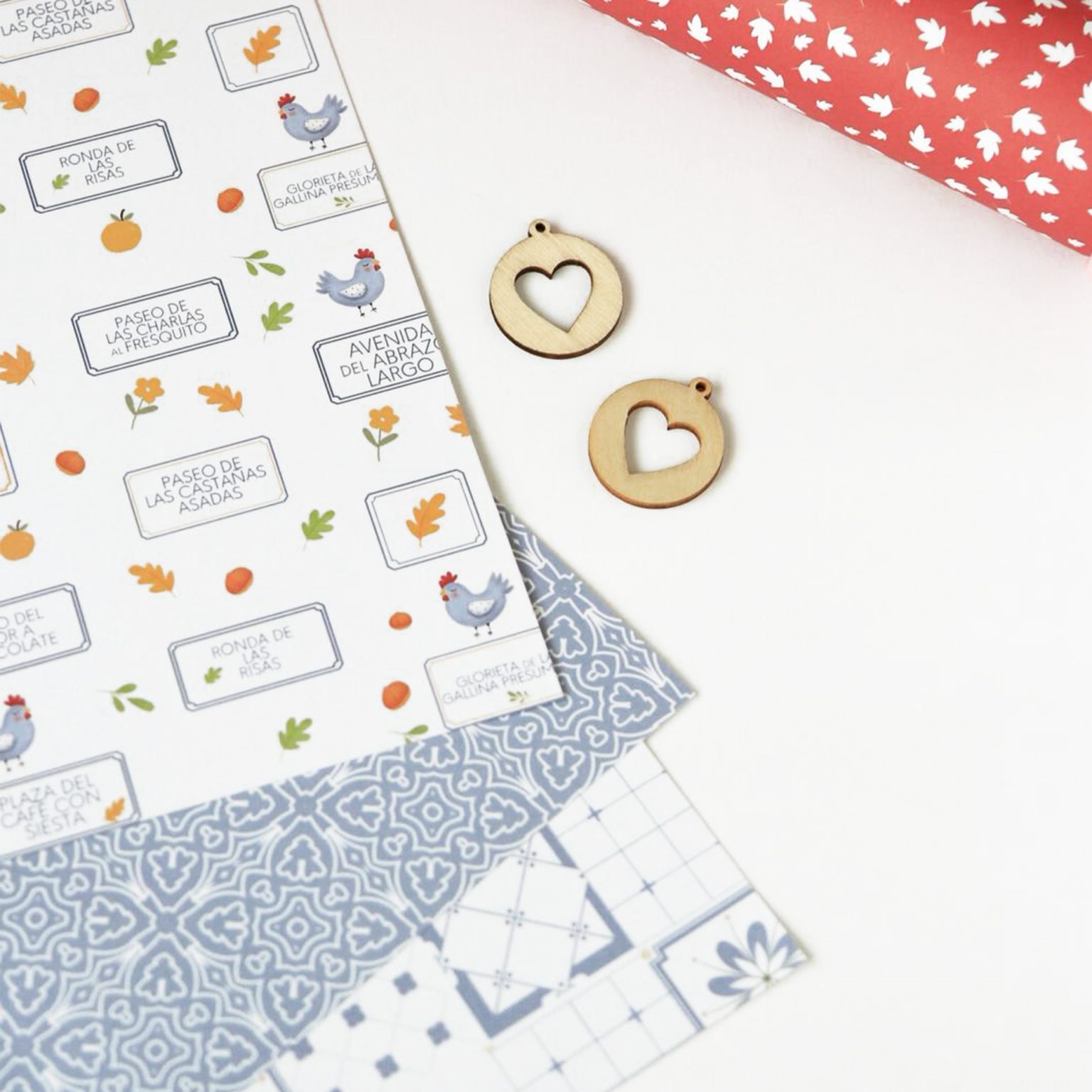 Folhas de papel decorativo colorido e etiquetas de madeira com coração recortado