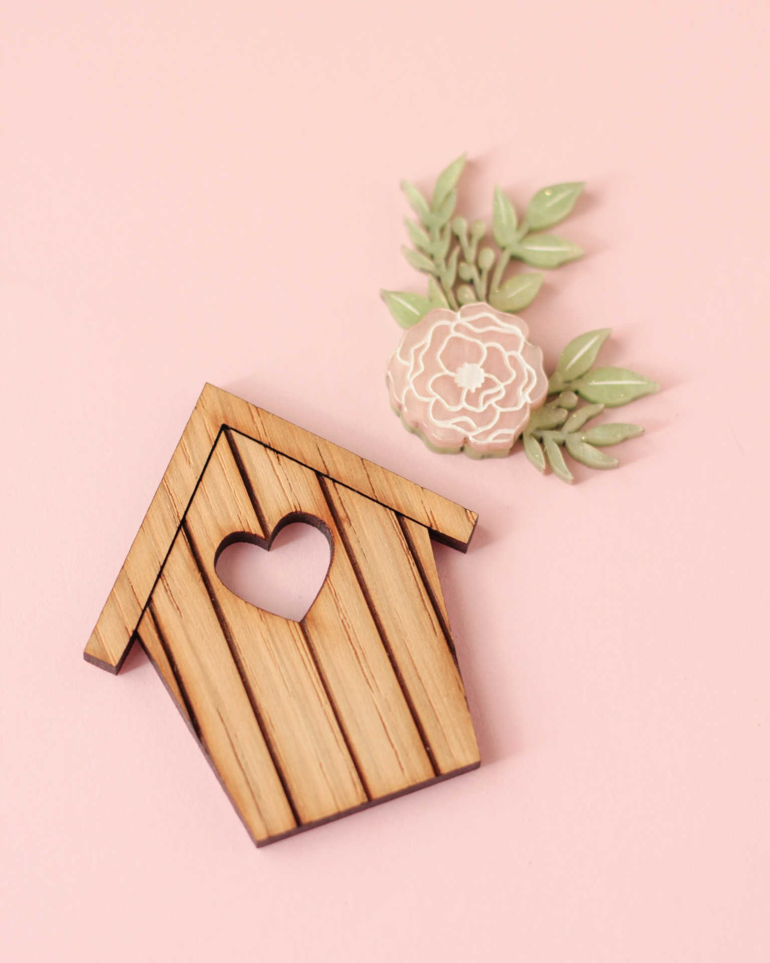 Casinha decorativa em madeira com corte de coração e flor rosa com folhas verdes