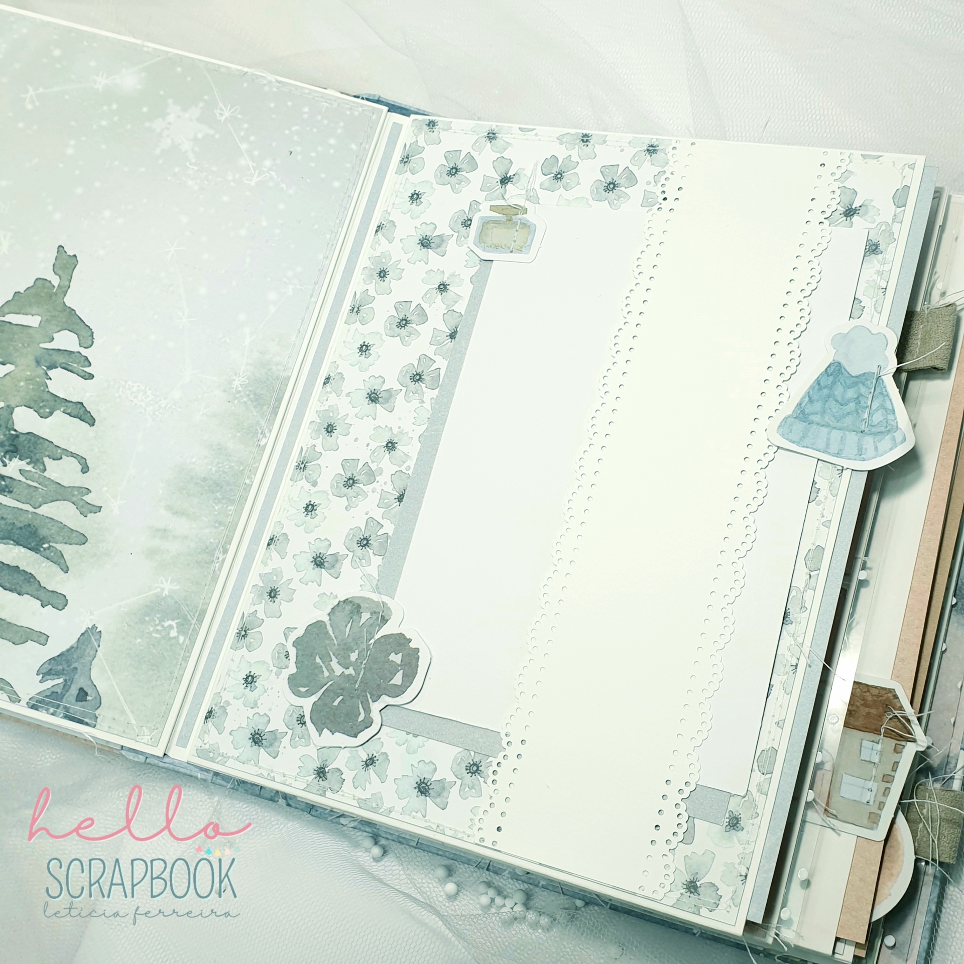 Página de scrapbook decorada com padrões florais e recortes azul claro