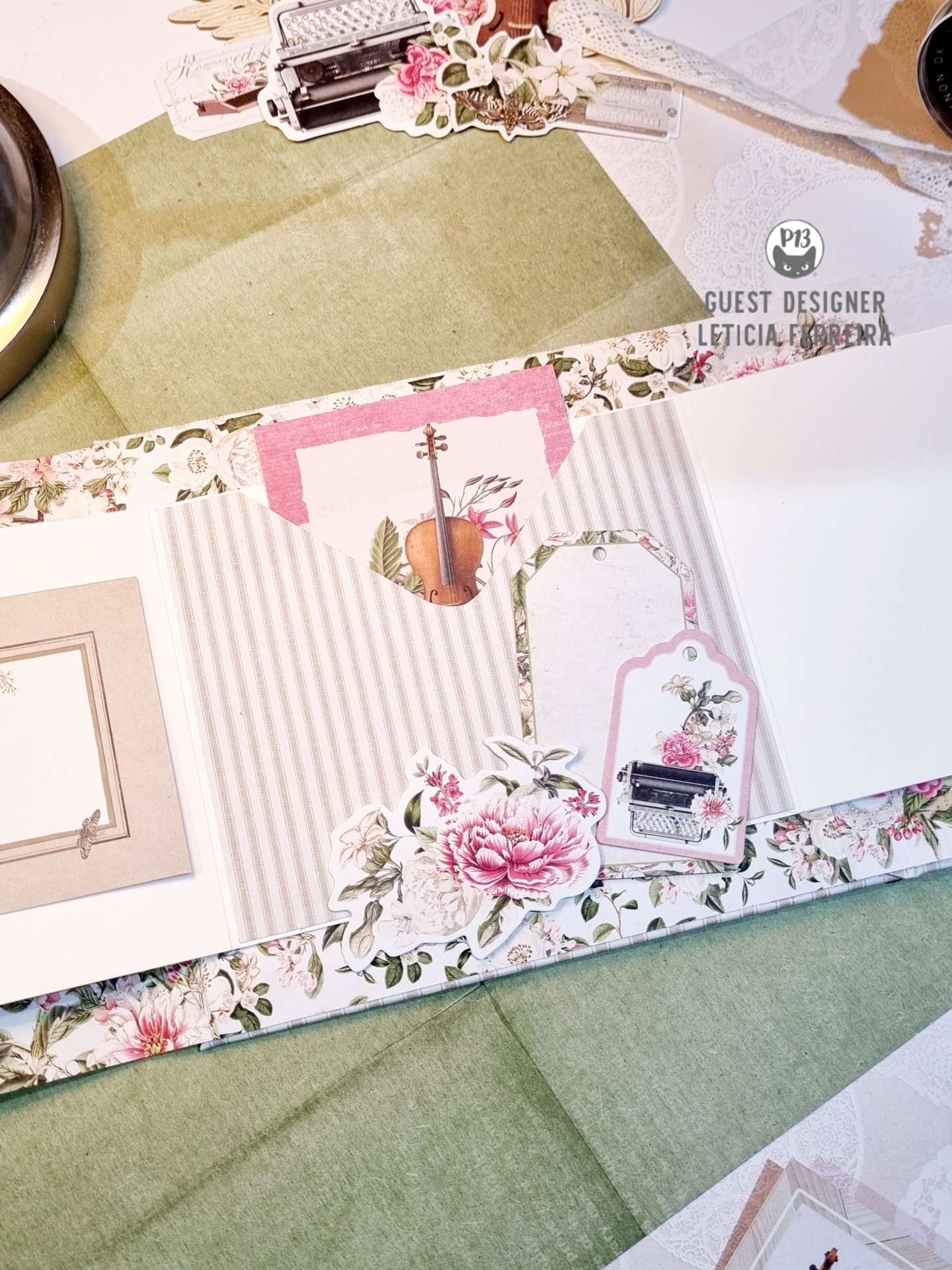 Scrapbook decorado com flores, violino e máquina de escrever em padrão riscado cinzento.