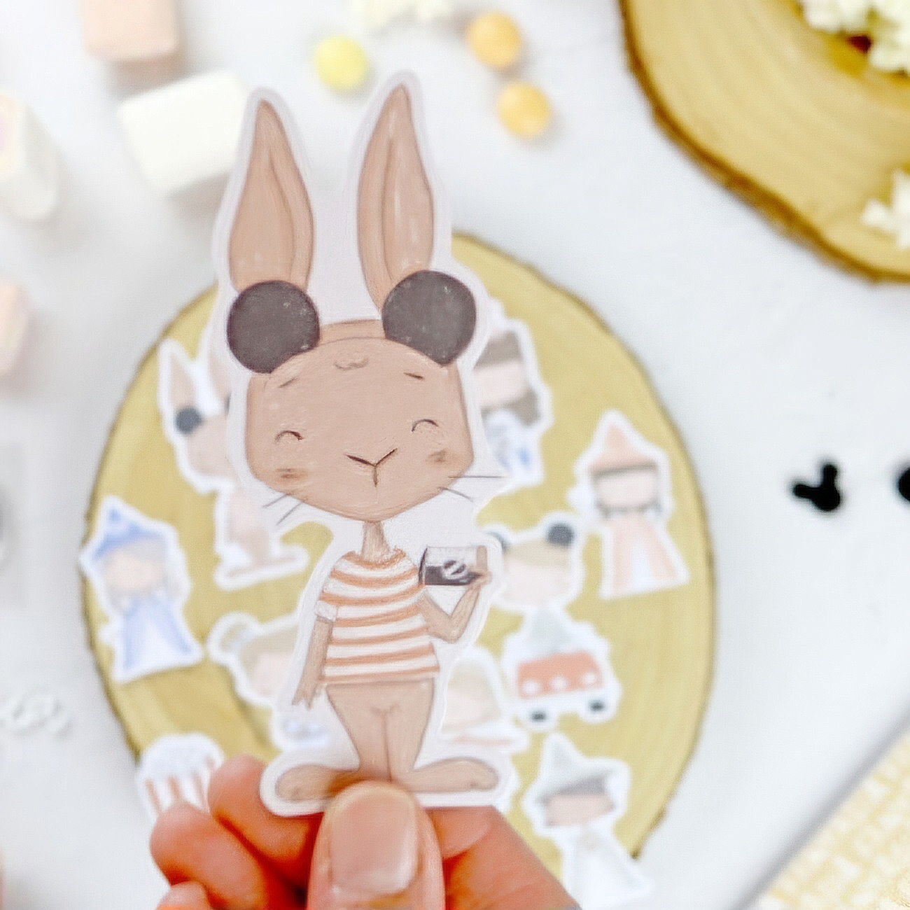 Autocolante/cartão recortado de coelho com roupa às riscas segurando uma caixa com coração.