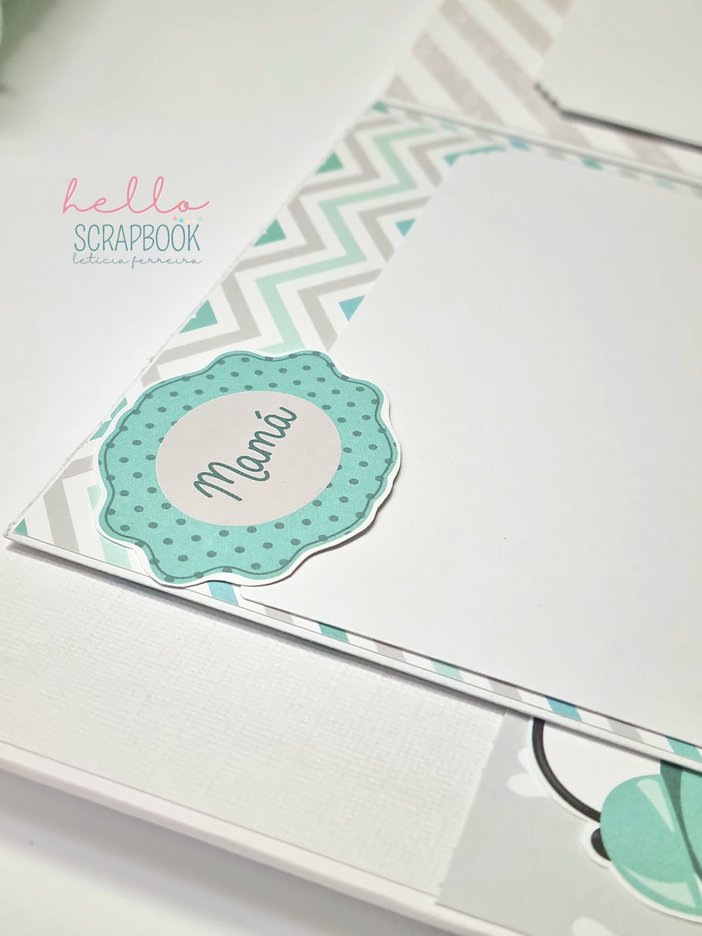 Página de scrapbook com padrão de ziguezague e etiqueta verde com a palavra Mamã