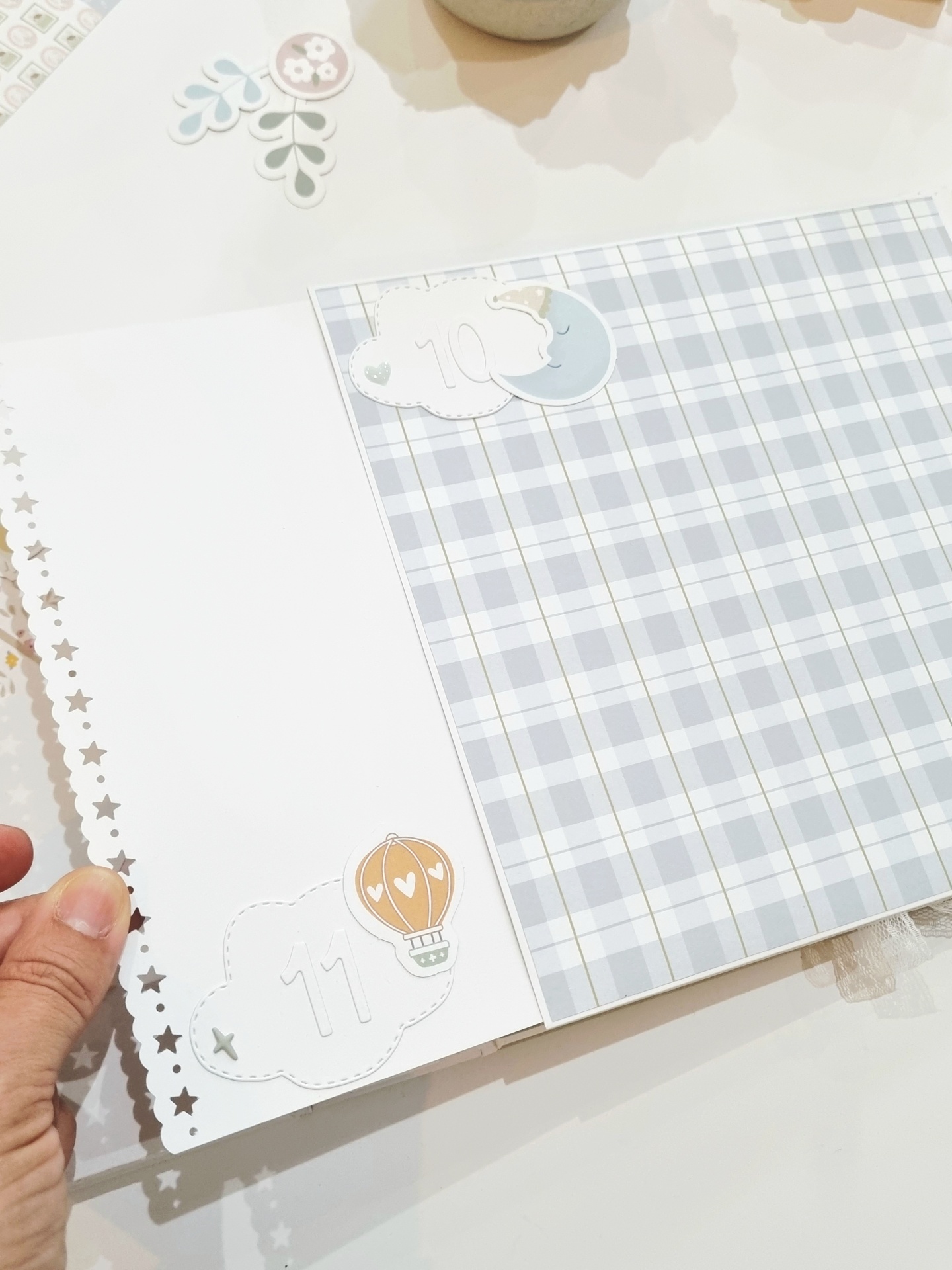 Página de scrapbook com padrão de xadrez e decoração de nuvens e balão
