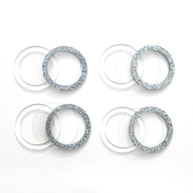 Conjuntos de anéis transparentes e prateados brilhantes sobre fundo branco