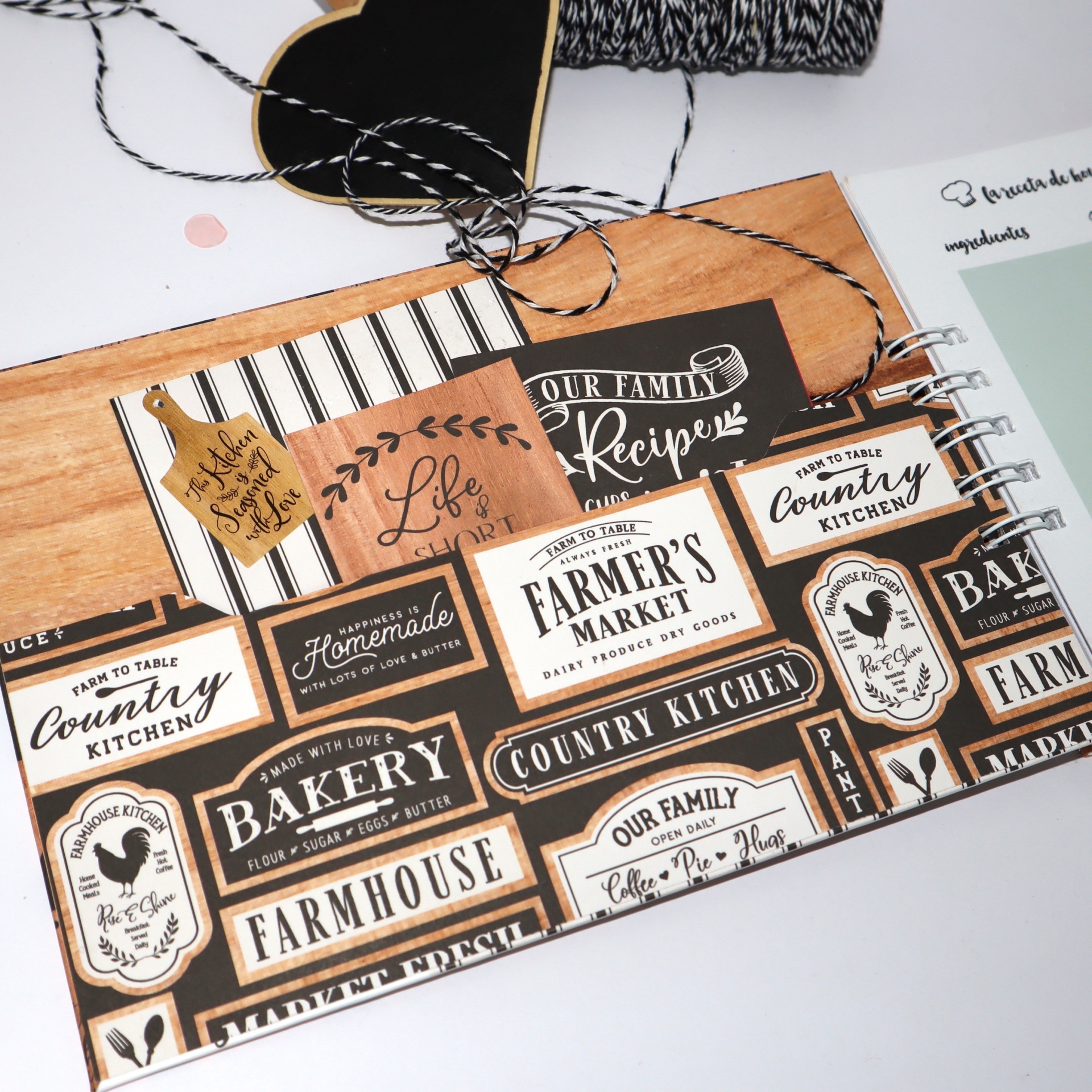 Folha com etiquetas decorativas de estilo vintage e cartão castanho com corda preta e branca ao lado.