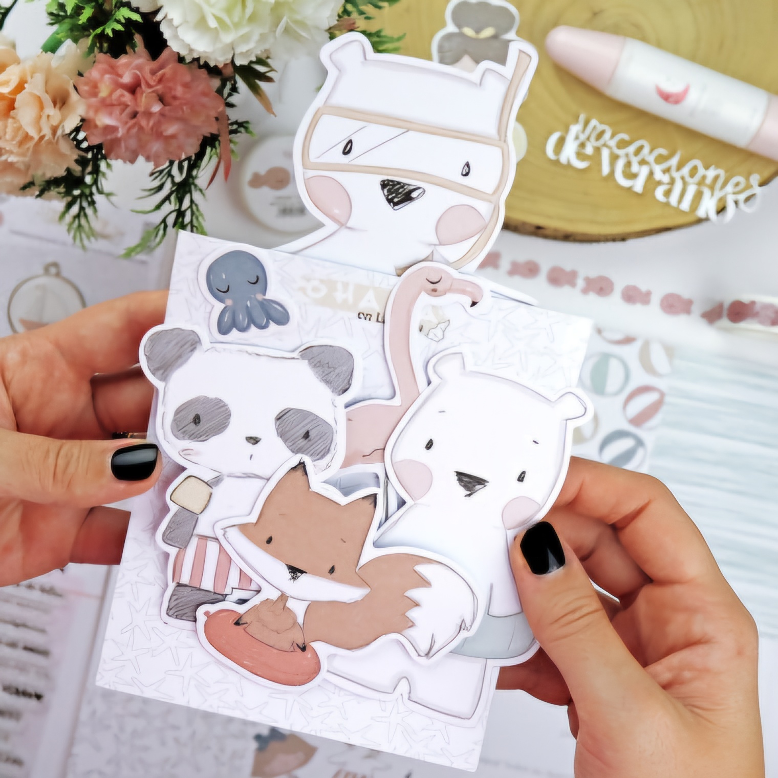 Marcadores de páginas com desenhos de animais segurados por uma mão, flores ao fundo