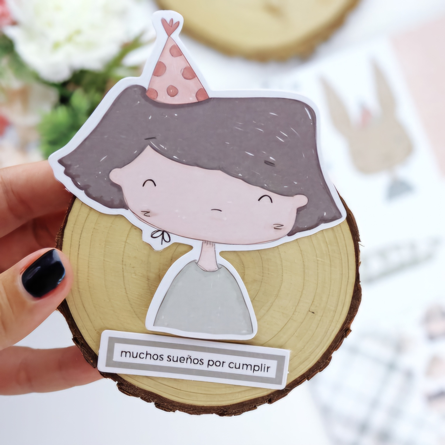 Disco de madeira com ilustração de menina cartoon e etiqueta com texto em espanhol