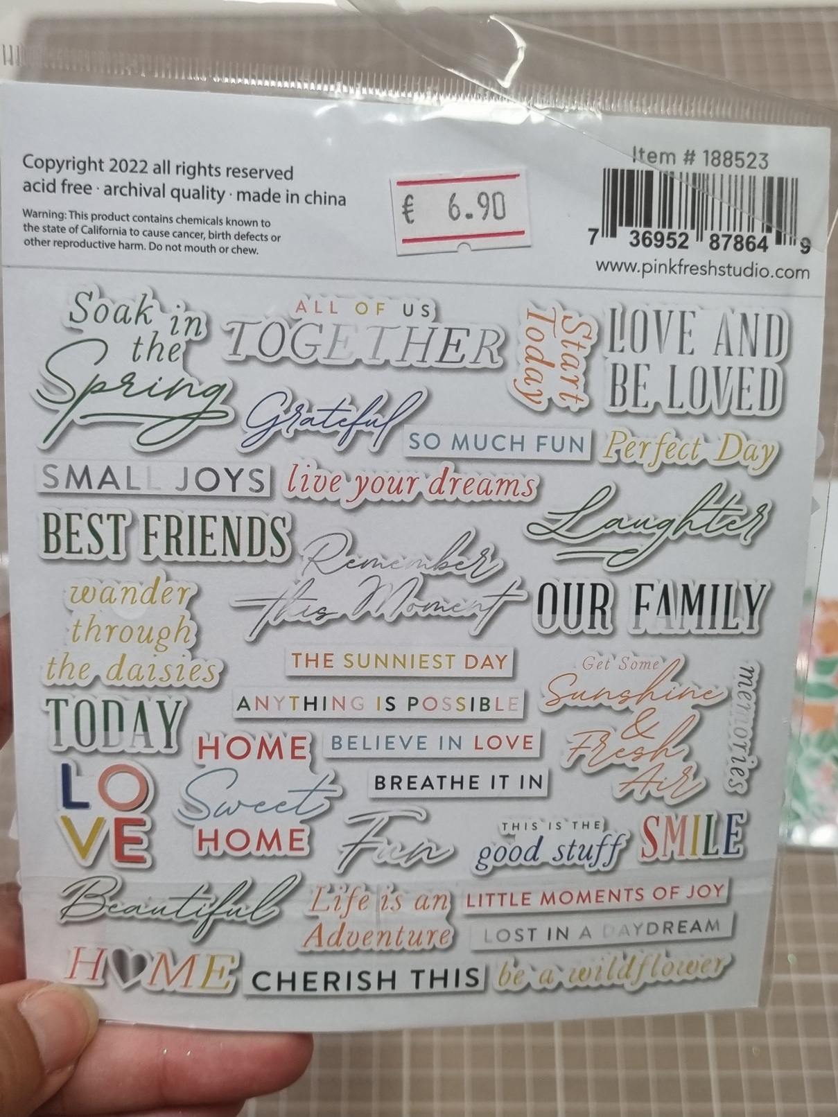 Folha de autocolantes com frases em várias cores e estilos numa embalagem com etiqueta de preço.