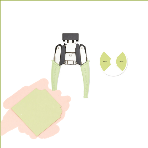 Ferramenta de corte com pegas verdes e formas de cartão coloridas