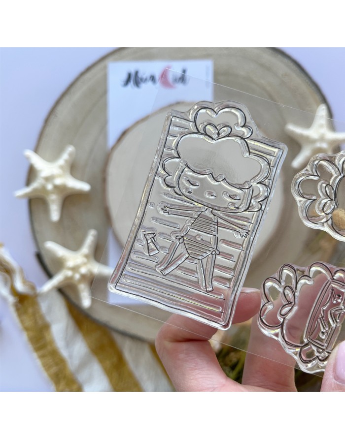 Carimbo transparente com desenho de personagem deitada numa toalha às riscas