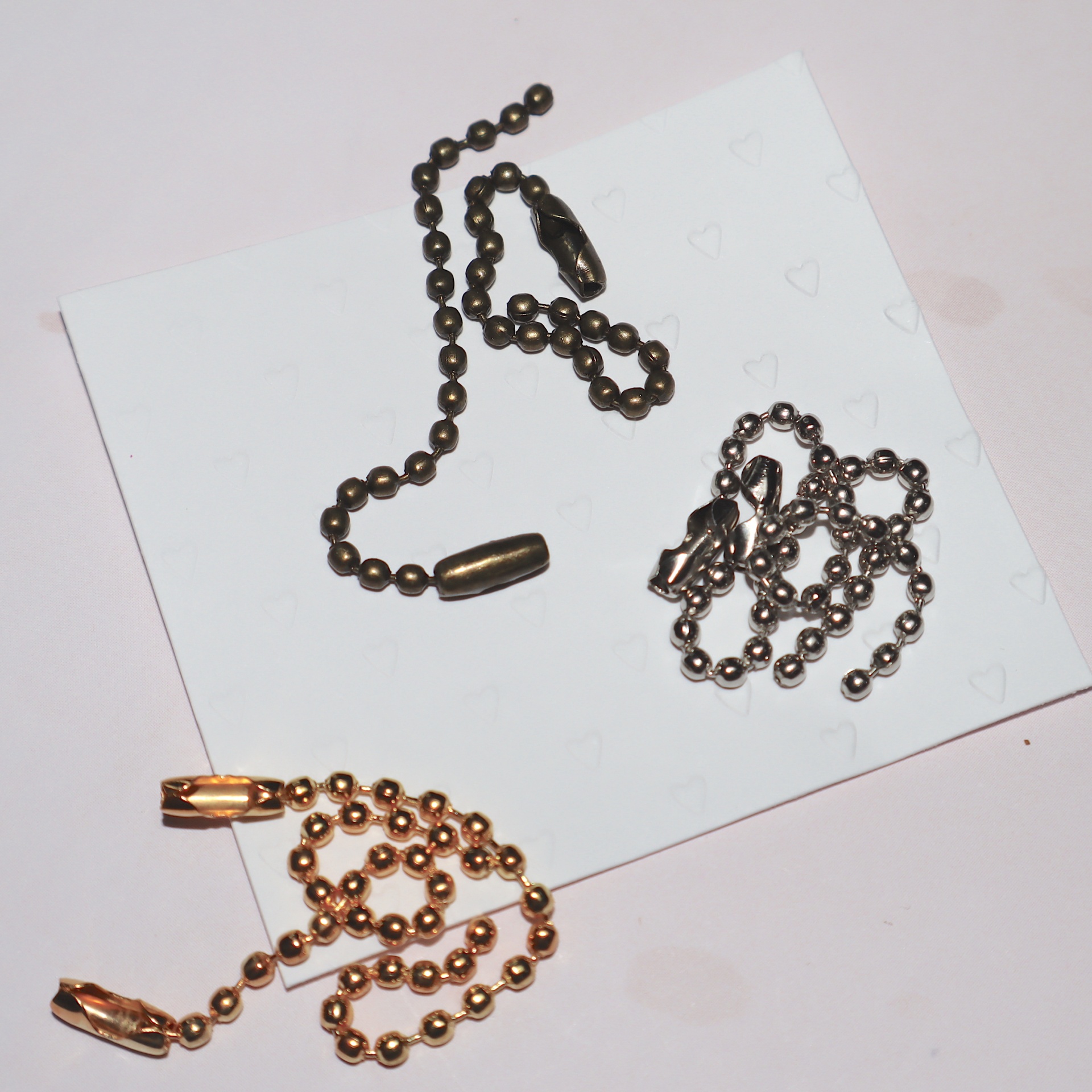 Três cadeias metálicas dourado, prateado e bronze com fechos