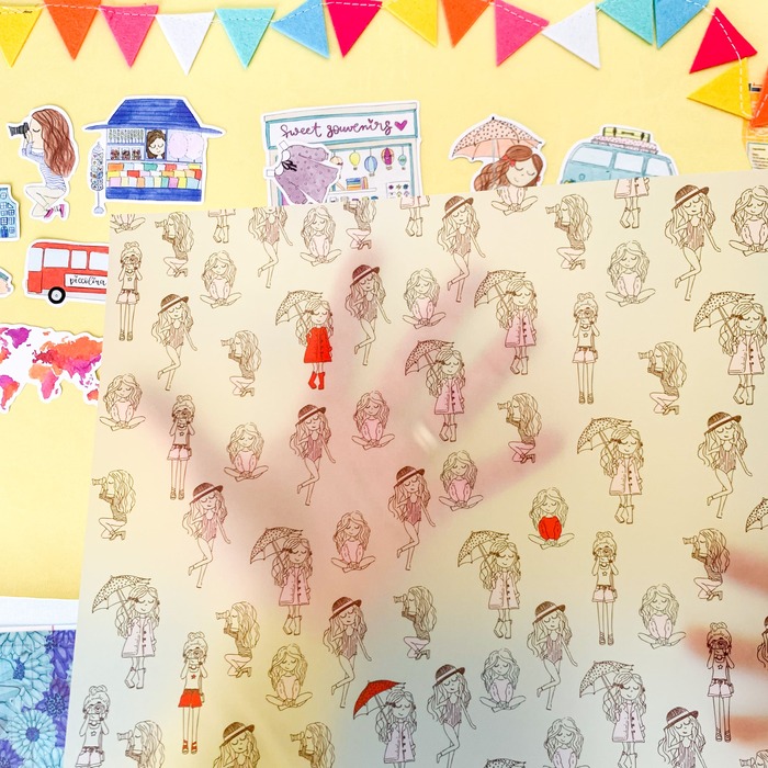 Folha de papel translúcido com desenhos de personagens femininas e autocolantes coloridos em fundo amarelo