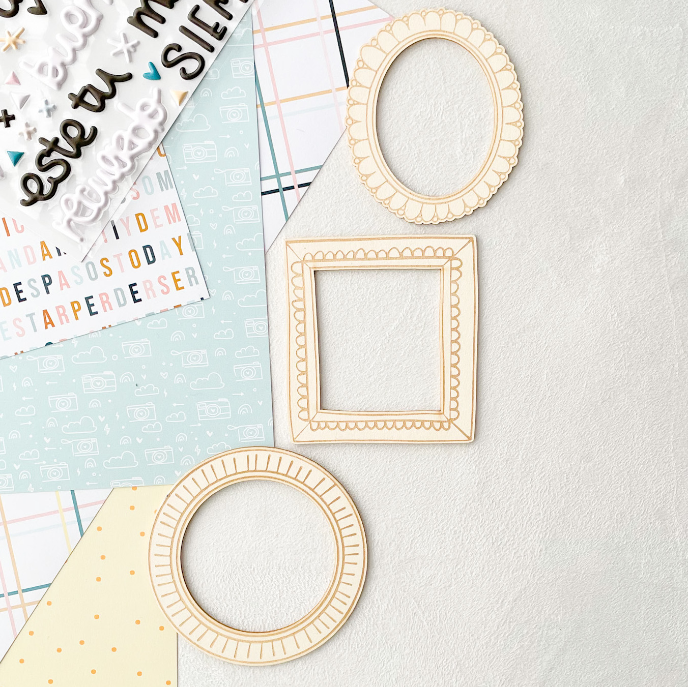 Três molduras decorativas de madeira clara e papéis coloridos com padrões e texto em português