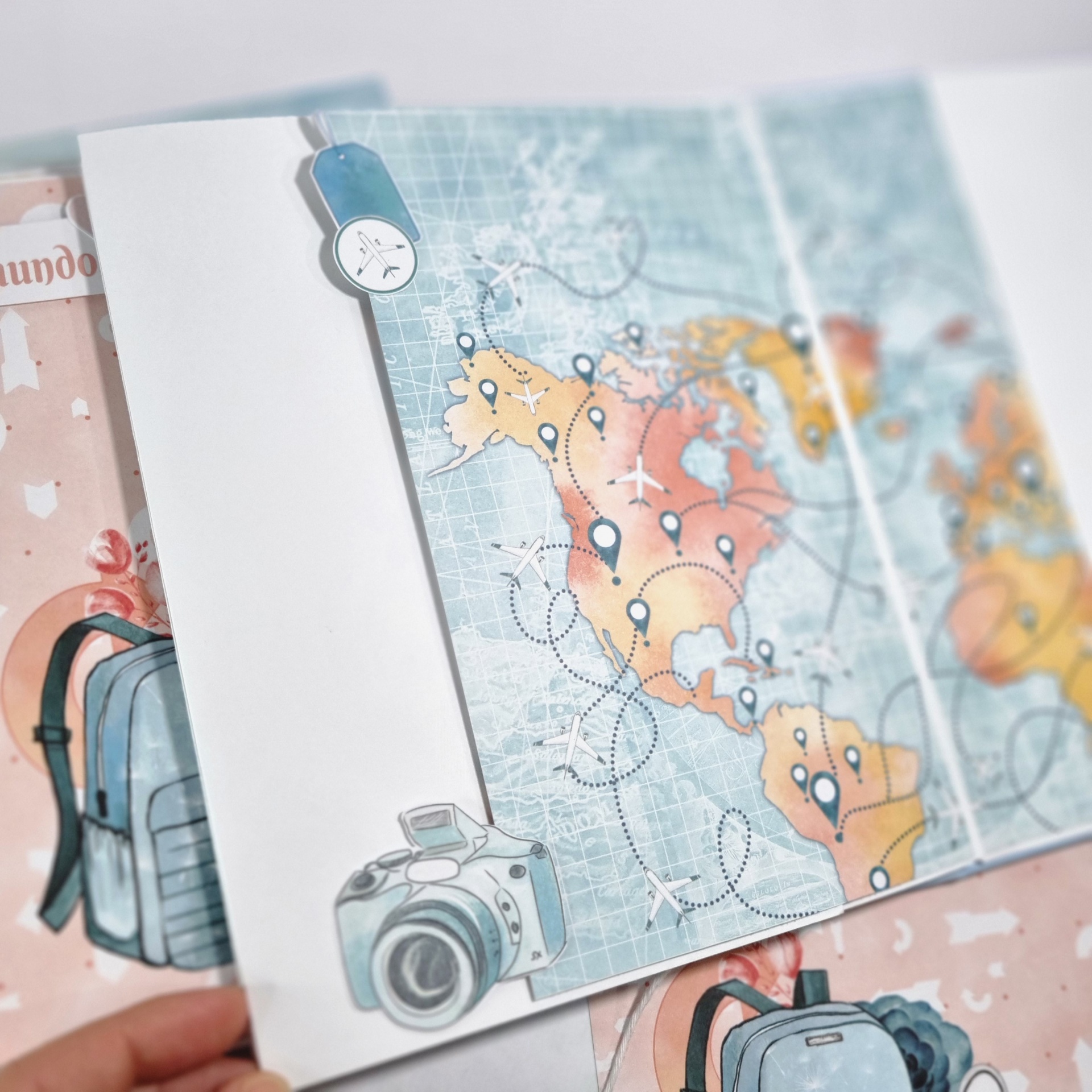 Cartão dobrável com mapa das Américas e ilustrações de relógio e câmera.