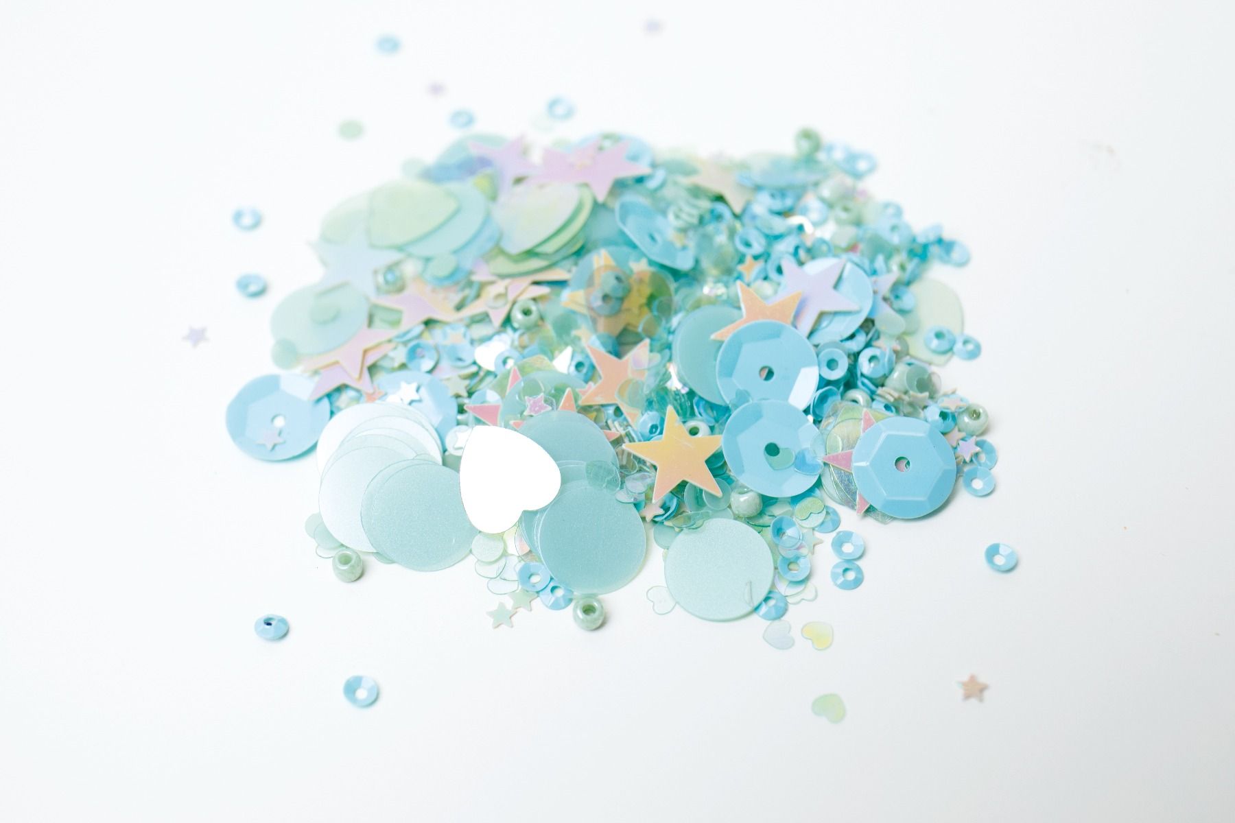 Confetes coloridos em azul e lilás com várias formas sobre fundo branco