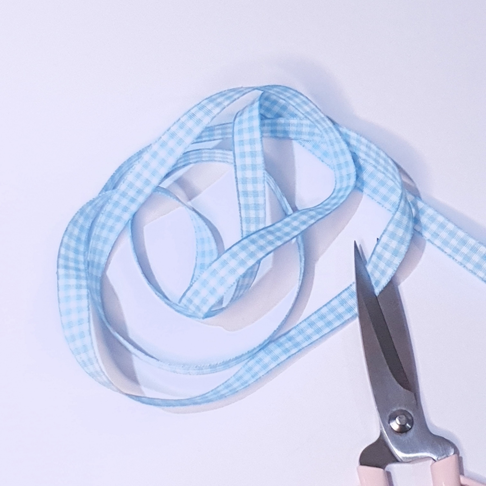 Fita decorativa azul clara xadrez com tesoura rosa