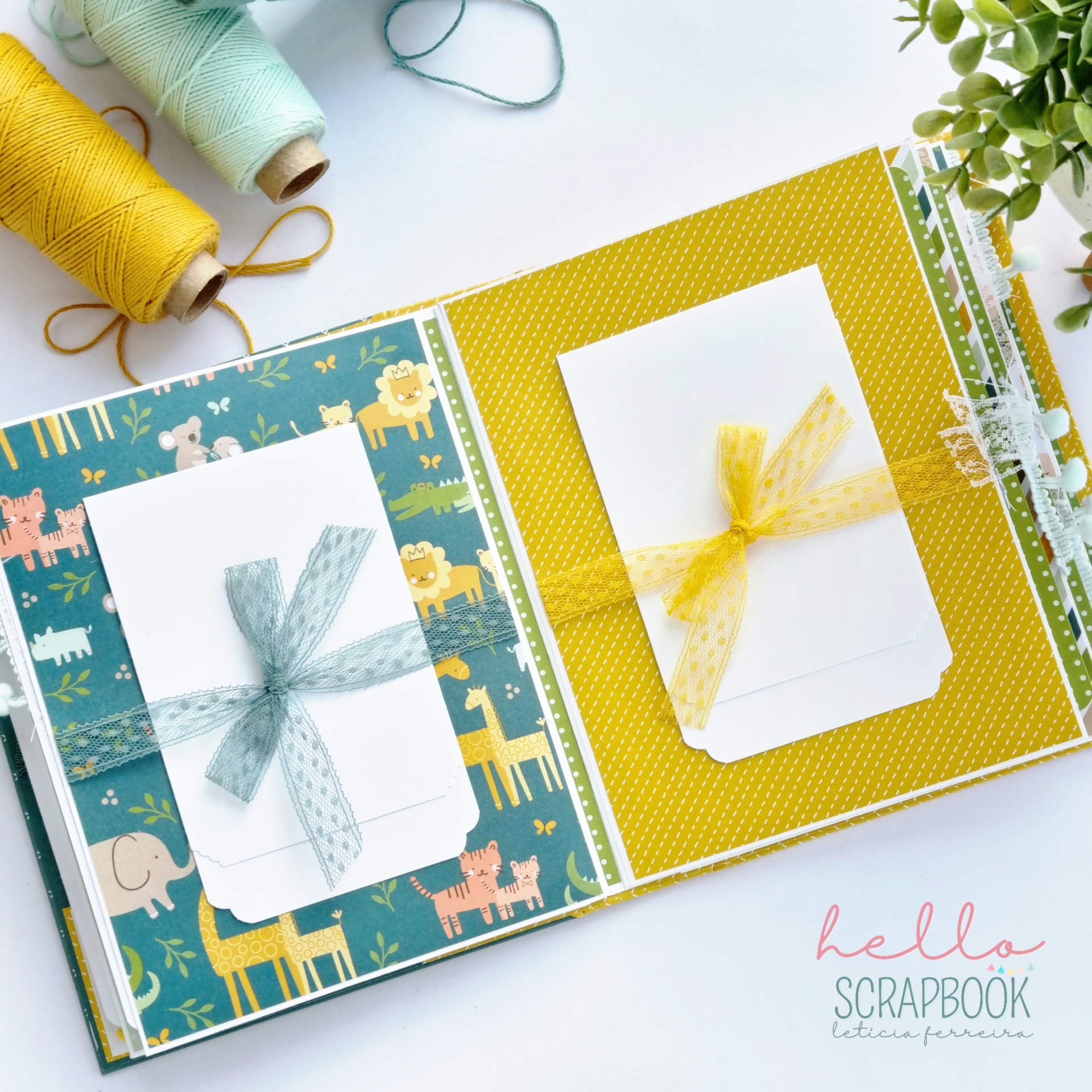 Álbum de scrapbook aberto com decoração colorida e cartões brancos com fitas azul e amarela