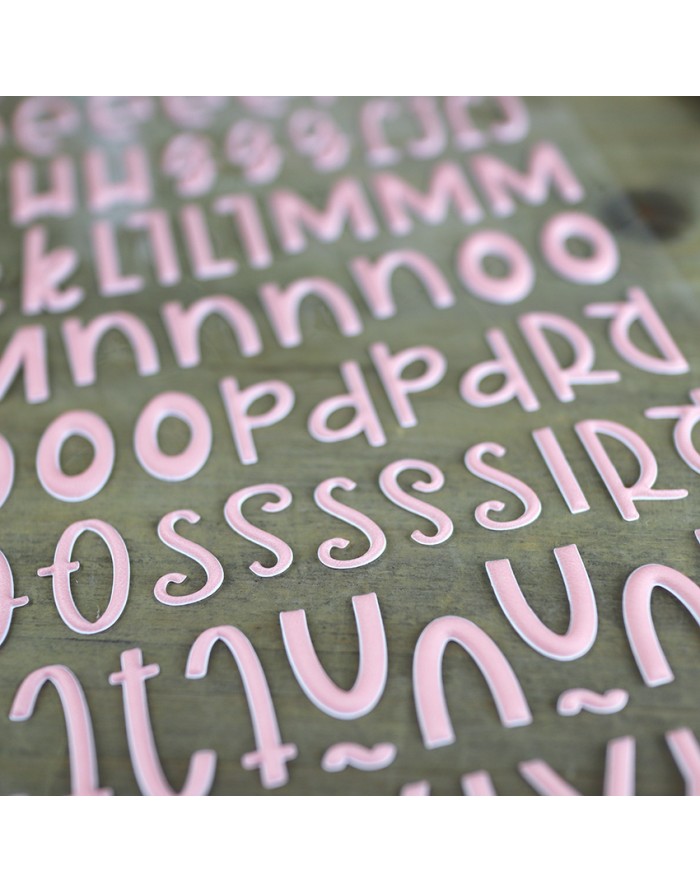 Letras e símbolos em relevo cor-de-rosa sobre uma superfície verde clara