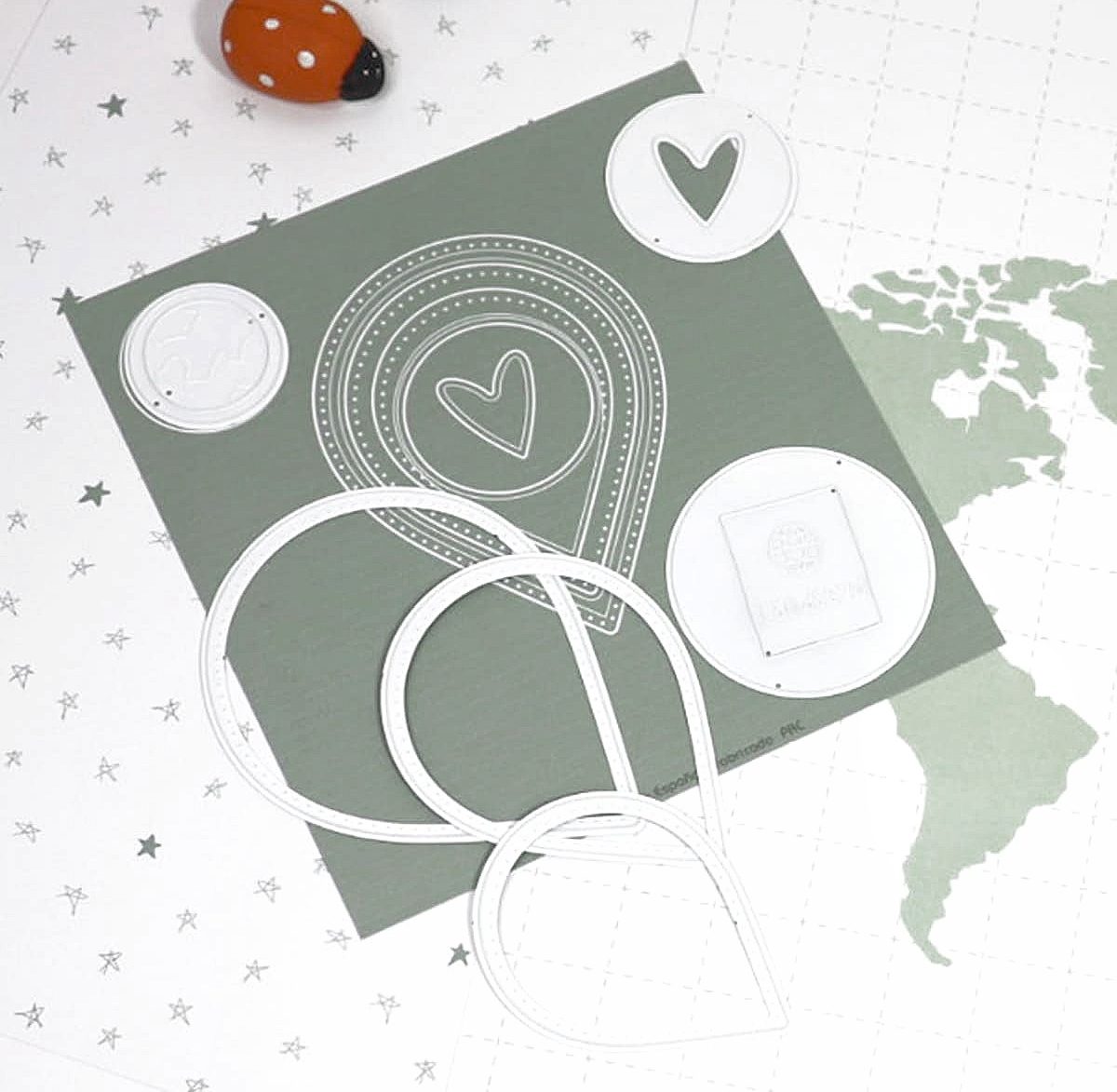 Moldes metálicos brancos com formas geométricas e coração sobre fundo com mapa e estrelas