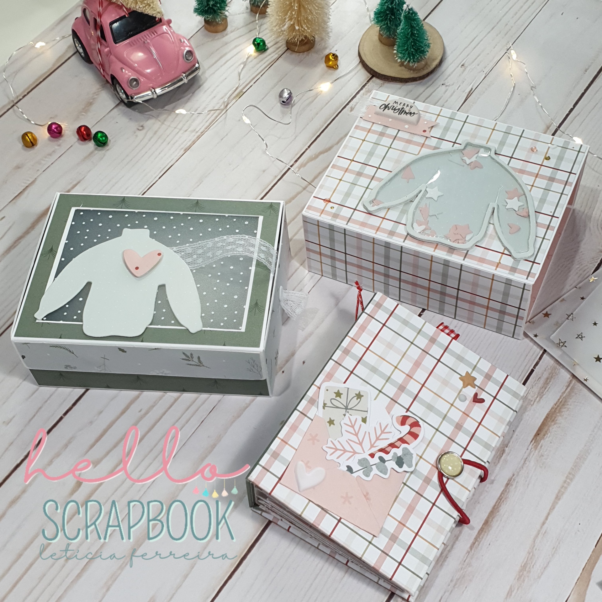 Três caixas decorativas de Natal com padrões e motivos festivos em mesa clara