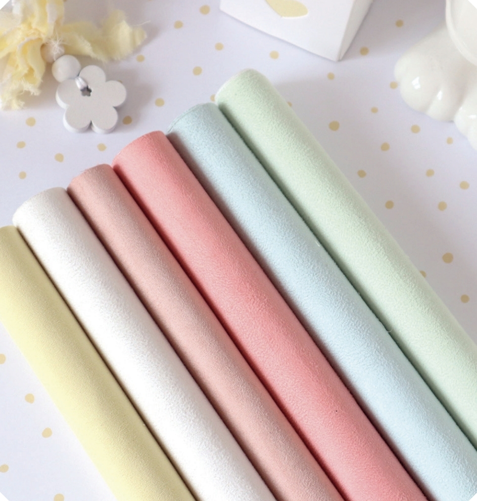 Seis rolos de tecido coloridos em tons pastéis dispostos lado a lado