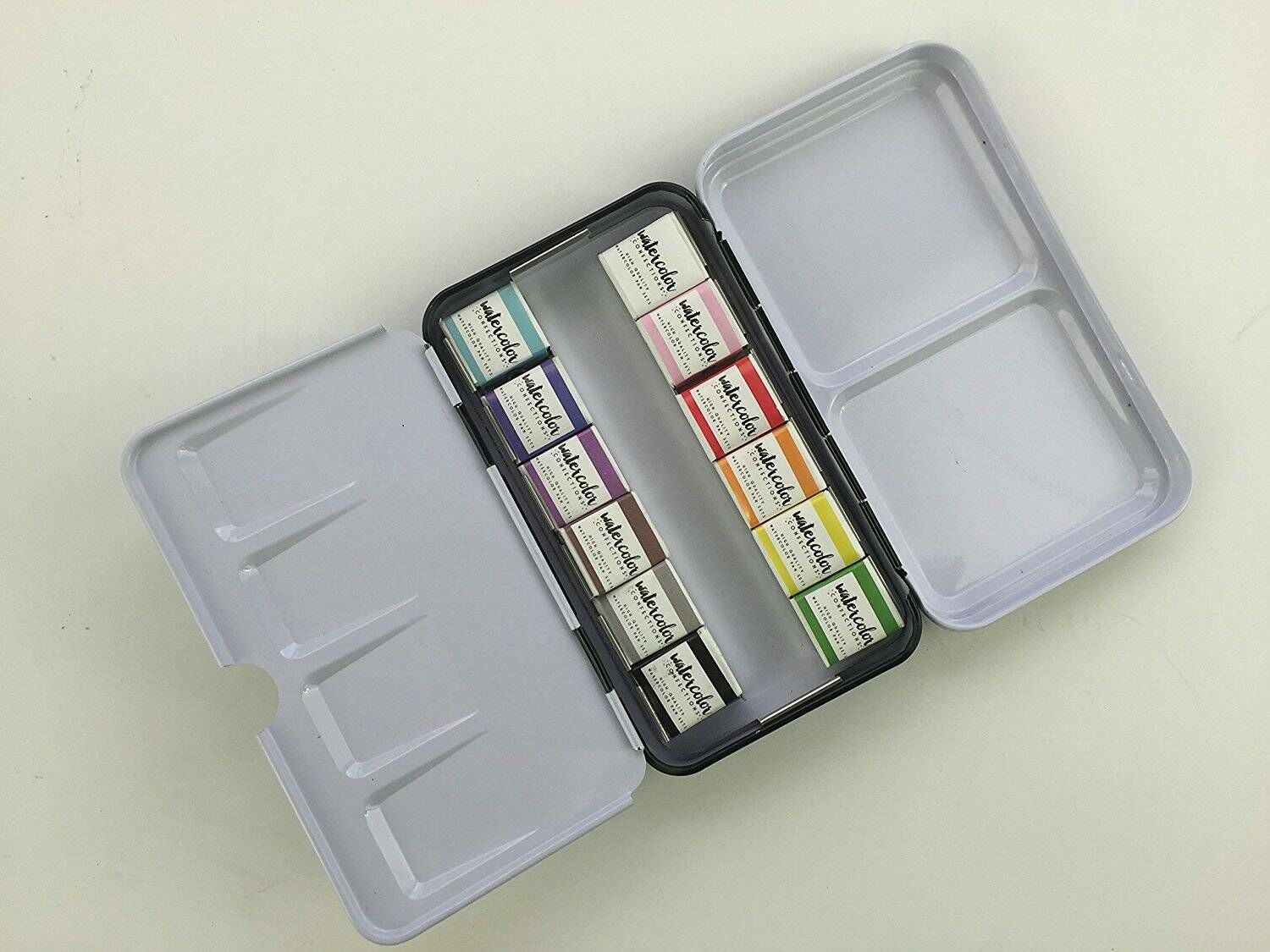 Estojo metálico aberto com pastilhas de aguarela coloridas