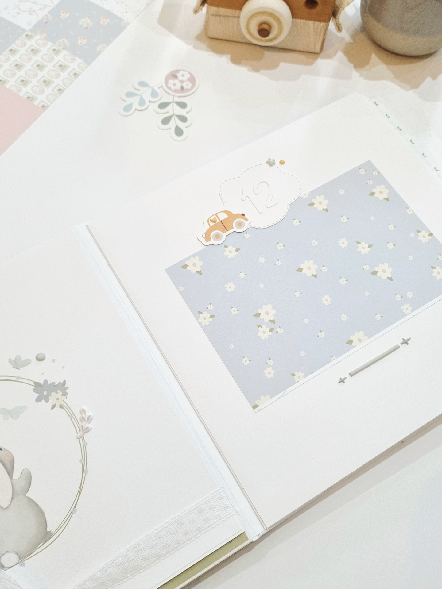 Livro de memórias para bebé com ilustrações e recortes decorativos em branco e azul claro
