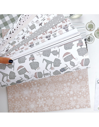 Folhas de papel decorativo com padrões de cães, flocos de neve e outros motivos em tons neutros