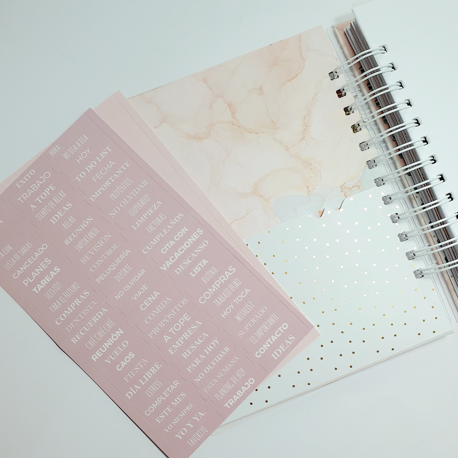 Dois cadernos espirais com capas decorativas e adesivos de organização rosa.