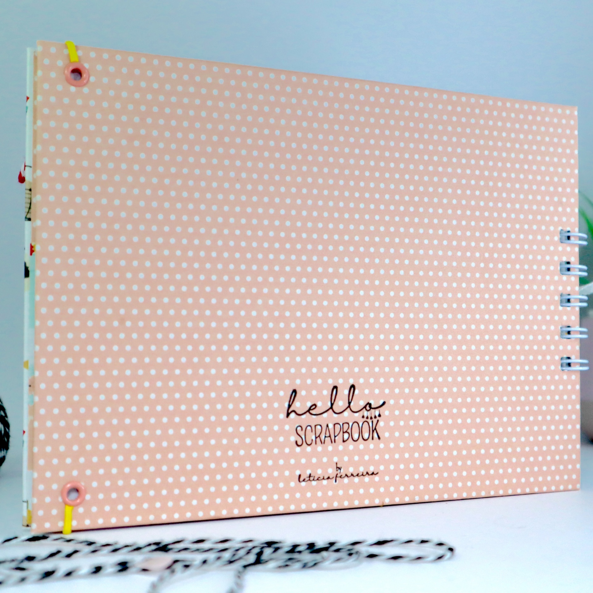 Álbum scrapbook rosa com padrão de pontos brancos e texto 'hello SCRAPBOOK'